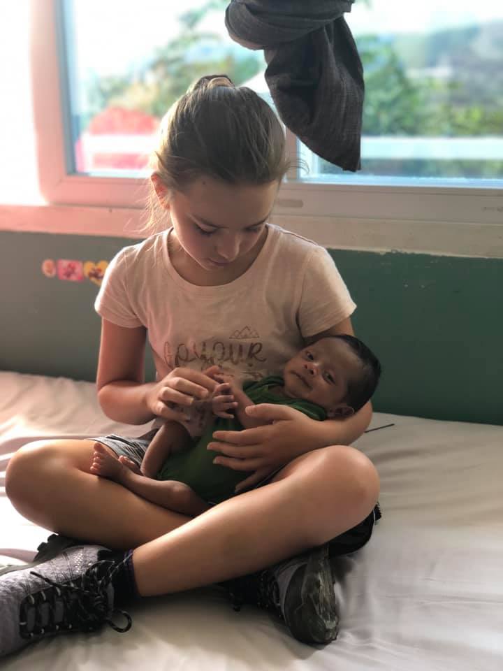 Keira holding a small baby during overseas mission trip